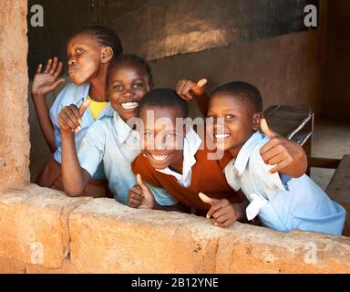 Si alzano i pollici e sorrisi da parte dei bambini in una fiorente scuola primaria vicino Al Voi nel Kenya meridionale Foto Stock