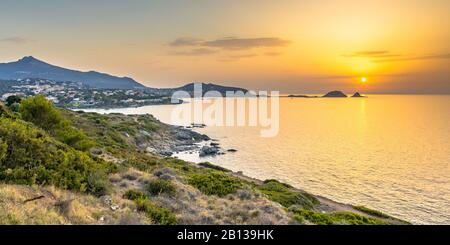 Tramonto d'oro sulla frastagliata costa orientale della Corsica con vista su Ile Rousse, Francia Foto Stock