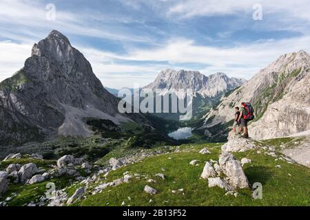 Escursionista con vista sul Seebensee con Zugspitze e Sonnenspitze, Wetterstein Mountains, Alpi, Tirolo, Austria, Europa Foto Stock