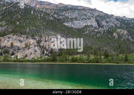 Le montagne si innalzano sopra la riva del Crown Lake nel Marble Canyon Provincial Park, British Columbia, Canada Foto Stock