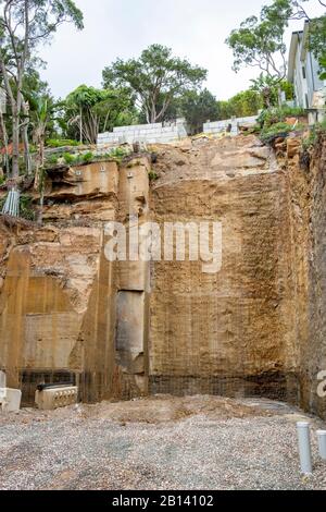 Australia, scavo profondo nella roccia per costruire una nuova casa di lusso in Palm Beach, Sydney, case adiacenti sostenuti durante lo scavo Foto Stock