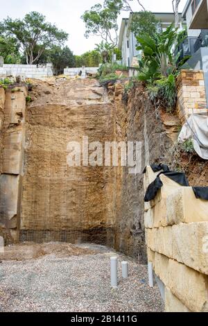 Australia, scavo profondo nella roccia per costruire una nuova casa di lusso in Palm Beach, Sydney, case adiacenti sostenuti durante lo scavo Foto Stock