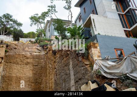 Australia, scavo profondo nella roccia per costruire una nuova casa di lusso in Palm Beach, Sydney, case adiacenti sostenuti durante lo scavo Foto Stock