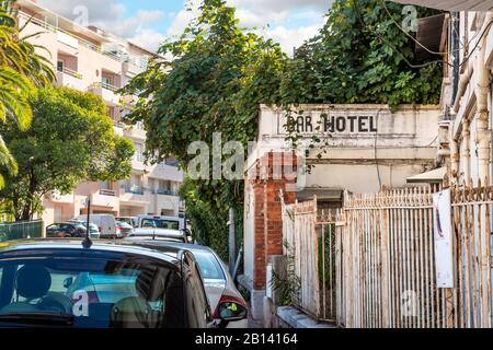 Un hotel bar coperto edera abbandonato in un quartiere residenziale di Menton, Francia. Foto Stock