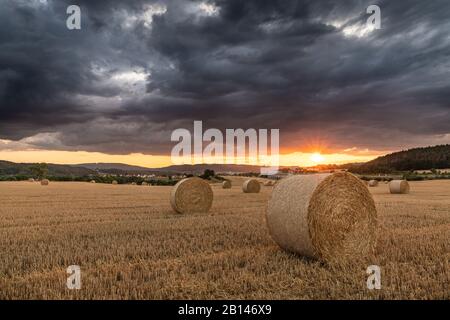 Tempesta su un campo stoppie al tramonto, Turingia, Germania Foto Stock