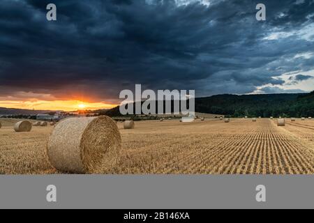 Tempesta su un campo stoppie al tramonto, Turingia, Germania Foto Stock