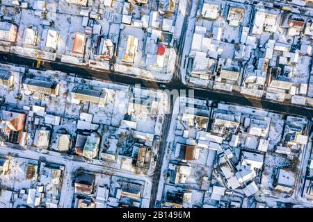 zona residenziale di periferia con case coperte di neve. vista aerea dall'alto in basso Foto Stock