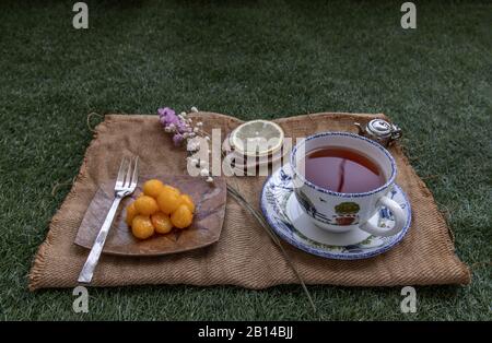 Pranzo - tè e limone Serviti con Thongyod (Dessert Thai) sul prato verde nel parco. Spazio di copia, fuoco selettivo. Foto Stock