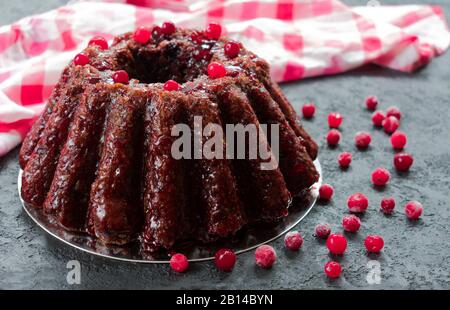 Torta al cioccolato, cupcake con ciliegie e mirtilli imbevuti di liquore su sfondo nero. Foto Stock