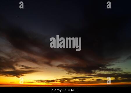 una foto aerea di un tramonto, cielo coperto di nuvole drammatiche, colori incredibili Foto Stock