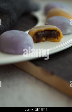 Mochi giapponesi multicolore in pasta di riso e su sfondo di legno. Tradizionale dessert giapponese. Foto Stock