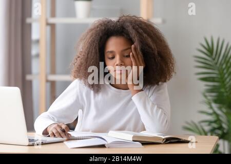 Annoiò studente africano americano teen stanco di imparare a fare i compiti Foto Stock