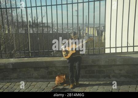 Chitarrista su un muro a Parigi con la Torre Eiffel in vista, pasakdek Foto Stock