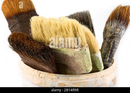Vecchie spazzole di vernice usate nella benna Foto Stock