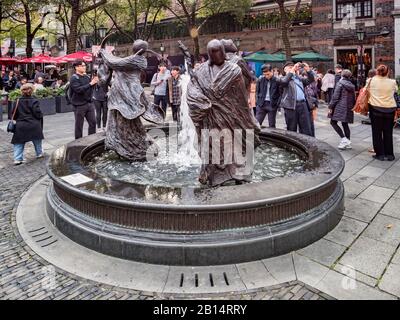 30 novembre 2018: Shanghai, Cina - I Visitatori intorno a una fontana con sculture raffiguranti fortuna, prosperità e longevità, nel quartiere Xintiandi Foto Stock