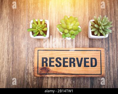 Cartello in legno riservato sulla cima di un tavolo in legno in un ristorante, posto per prenotazioni al ristorante per incontri su tema festeggiato. Segno riservato da