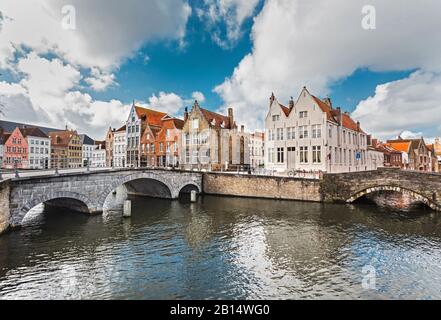 Vecchie case in pietra colorate vicino al canale sono il punto di riferimento di Bruges, Belgio. I canali di Bruges con vecchi ponti in pietra sono famose attrazioni turistiche. Foto Stock