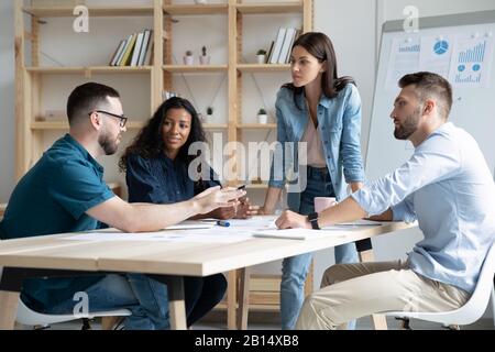 Dipendenti aziendali di razza mista concentrati che discutono il progetto. Foto Stock