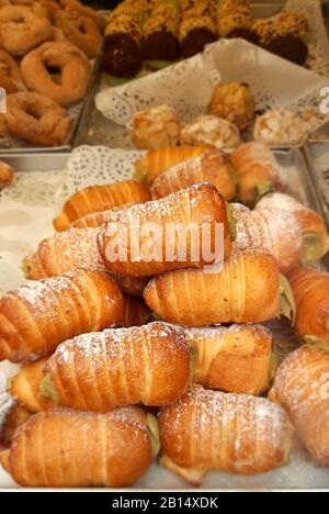 Il vassoio di cannoli con crema per la vendita in un negozio di pasticceria Foto Stock