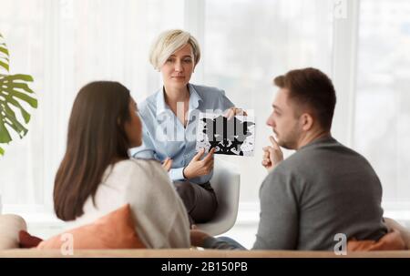 Psicologo Professionista Che Mostra La Coppia Di Test Delle Immagini Inkblot Seduta In Ufficio Foto Stock