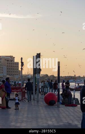 Dubai, Emirati Arabi Uniti - 30 DICEMBRE 2017: Persone che camminano al tramonto sul Dubai Creek Foto Stock