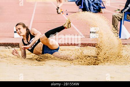 salto lungo in pista e evento sul campo donna atleta Foto Stock