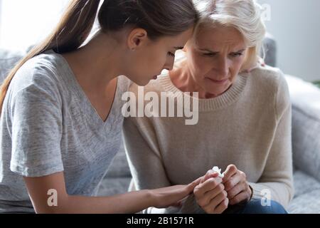 Preoccupante signora millennial seduta accanto a sconvolto mamma frustrata. Foto Stock