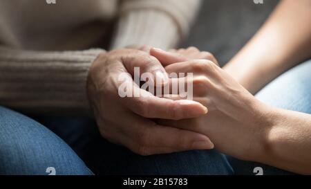 Primo piano mummys di mezza età stropicciato mani tenere figlie giovani. Foto Stock