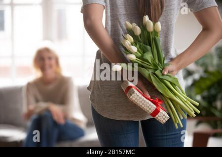 Primo piano giovane donna con nascosto dietro dono posteriore. Foto Stock