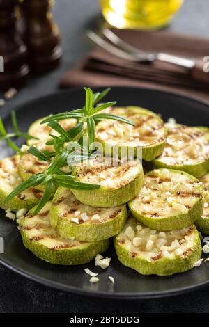 Zucchine grigliate, zucchine con aglio e rosmarino su piastra Foto Stock