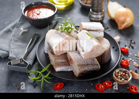 Pesce di nasello fresco crudo a fette con ingredienti per cucinare Foto Stock