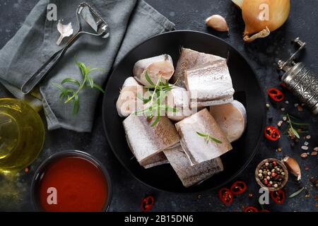 Pesce di nasello fresco crudo a fette con ingredienti per cucinare Foto Stock