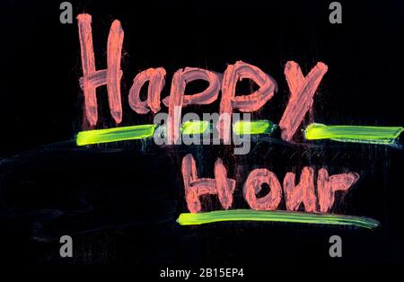Happy hour scritto in rosa su lavagna nera con gesso Foto Stock