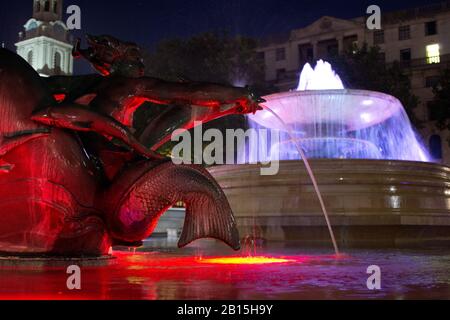Foto notturna di statue e fontane illuminate a Trafalgar Square a Londra, Inghilterra Foto Stock