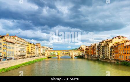 Il Ponte Vecchio sulla riva del fiume Arno a Firenze, Italia Foto Stock