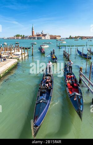Venezia, Italia - 21 maggio 2017: Le gondole con i turisti navigano nel canale dalla laguna veneta. San Giorgio maggiore sullo sfondo. La Foto Stock