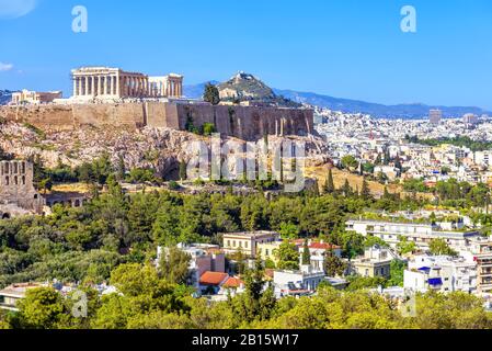 Atene in estate, Grecia. La famosa collina dell'Acropoli sorge sopra il paesaggio urbano. E' il punto di riferimento principale di Atene. Vista panoramica delle antiche rovine greche. Paesaggio di Foto Stock