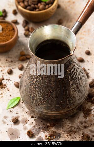 Caffè del mattino. Caffè turco in turco e chicchi di caffè su un piano di pietra o ardesia. Foto Stock