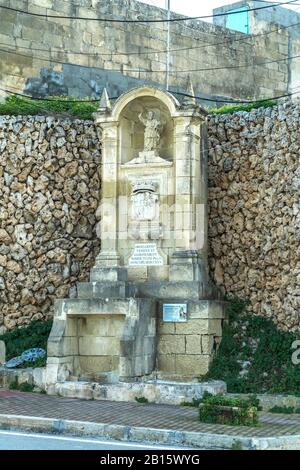 Malta, Baia di San Paolo: Storica Fontana dell'Apostolo o Ghajn Razul con la statua di San Paolo. Foto Stock