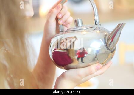 Ragazza che tiene un bollitore Foto Stock