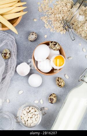 Cibo ricco di biotina. Fonti naturali di vitamina B7. Cibo: Latte uova fagioli farina d'avena mais su sfondo blu, cibo naturale vista dall'alto piatto lay-up da vicino Foto Stock