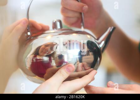 Ragazza che tiene un bollitore Foto Stock