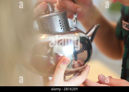 Ragazza che tiene un bollitore Foto Stock