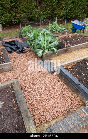 Installazione di membrana o tessuto di controllo delle erbacce e percorso di ghiaia in un giardino in Inghilterra, Regno Unito Foto Stock