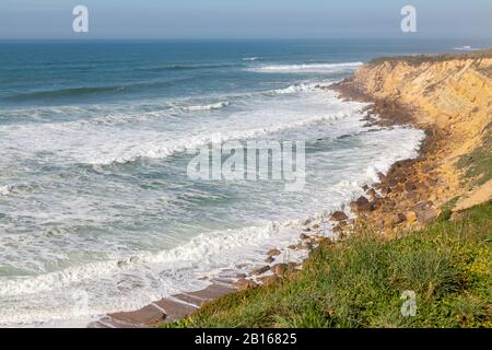 Ocean Coast con erba, moviment onde con schiuma. Energia eolica. Acque turchesi. Foto Stock