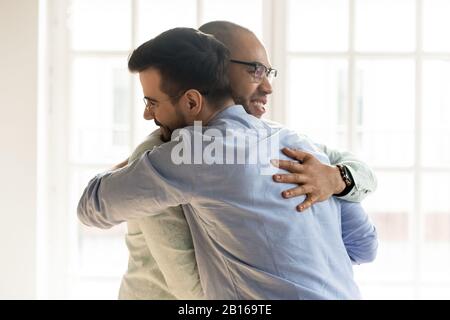 I ragazzi africani e caucasici abbracciano felice di vedersi Foto Stock