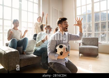 Ragazzo entusiasta con gli amici che festeggiano la vittoria della squadra di calcio preferita Foto Stock