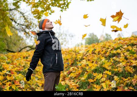 Uomo nell'estate indiana. Con foglie di alberi. Foto Stock