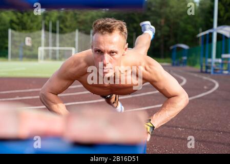 L'uomo sta spingendo in alto dal banco Foto Stock