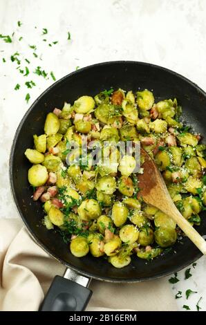 Padella con germogli di Brussel tostati su fondo bianco. Vista dall'alto. Foto Stock